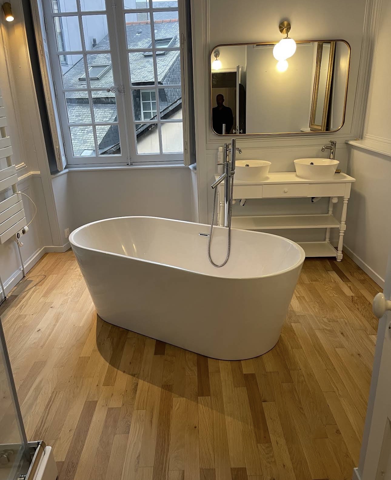 Salle de bain avec parquet chêne rénové et baignoire îlot